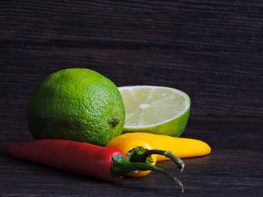 Koyu arkaplanda sarı ve kırmızı biber ve kireç.