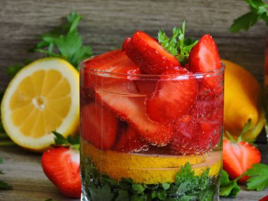 Limonlu maydanoz için. Susuzluğu gidermek için iç. Limonlu maydanozlu çilek. İkiye bölünmüş taze çilek. Boşluğu kopyala.