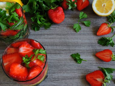 Limonlu maydanoz için. Susuzluğu gidermek için iç. Limonlu maydanozlu çilek. İkiye bölünmüş taze çilek. Boşluğu kopyala.