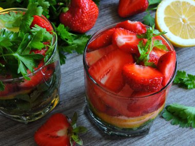 Limonlu maydanoz için. Susuzluğu gidermek için iç. Limonlu maydanozlu çilek. İkiye bölünmüş taze çilek. Boşluğu kopyala.