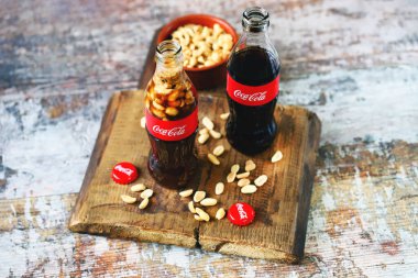 Kharkiv / Ukrayna - 6 Haziran 2020: Seçici odaklanma. Makro. Fıstıklı Coca Cola şişesi. Coca Cola 'lı fıstık. Geleneksel Amerikan yemeği. Kokain şişesine atılmış fıstık. Şişe içinde yiyecek ve içecek..