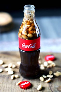 Kharkiv / Ukrayna - 6 Haziran 2020: Seçici odaklanma. Makro. Fıstıklı Coca Cola şişesi. Coca Cola 'lı fıstık. Geleneksel Amerikan yemeği. Kokain şişesine atılmış fıstık. Şişe içinde yiyecek ve içecek..