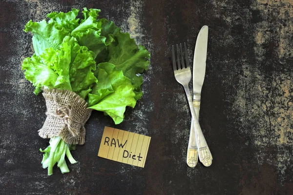 Raw diet concept. Green fresh lettuce leaves frame and a note that says raw diet.