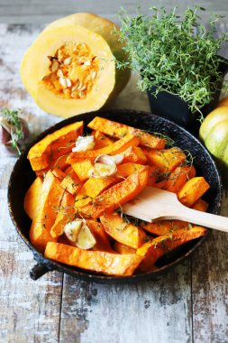 Pişirmeden önce kekik ve sarımsaklı bir tavada dilimlenmiş balkabağı. Balkabağı pişiriyorum..