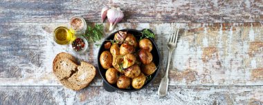 Tavadaki kırsal patates. Sarımsak ve bitkilerle kabuklu küçük patatesler..