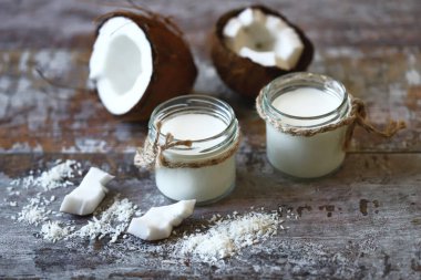 Keto diyeti. Keto içiyor. Kavanozlar dolusu hindistan cevizi sütü, hindistan cevizi gevreği, hindistan cevizi. Hindistan cevizi sütü. Vejetaryen sütü. Seçici odaklanma. Makro.