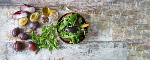 Light salad with arugula and plums. Autumn plum salad. Healthy food.