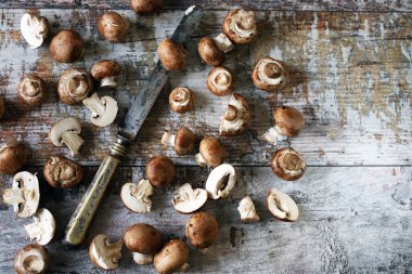 Tahta bir yüzeyde kraliyet şampiyonları ve bıçak. Kahverengi şampiyonlar. Seçici odaklanma. Makro.
