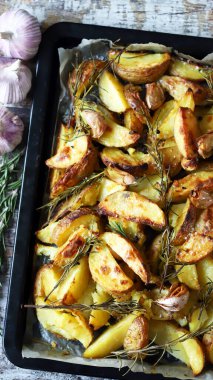 Kırsal altın fırında patates. Baharatlı, sarımsaklı ve biberiyeli fırında patates. Vejetaryen yemeği. Noel yemeği. Makro. Seçici odak.