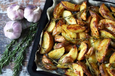 Kırsal altın fırında patates. Baharatlı, sarımsaklı ve biberiyeli fırında patates. Vejetaryen yemeği. Noel yemeği. Makro. Seçici odak.