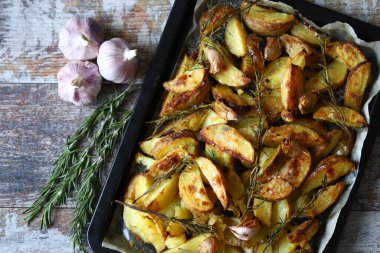 Kırsal altın fırında patates. Baharatlı, sarımsaklı ve biberiyeli fırında patates. Vejetaryen yemeği. Noel yemeği. Makro. Seçici odak.