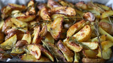Kırsal altın fırında patates. Baharatlı, sarımsaklı ve biberiyeli fırında patates. Vejetaryen yemeği. Noel yemeği. Makro. Seçici odak.