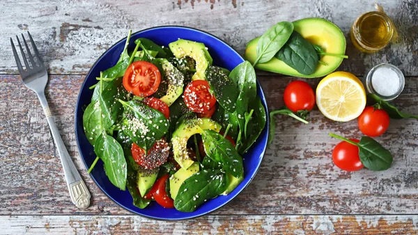 Healthy vegan salad with avocado and chia seeds. Salad with spinach, tomatoes and avocado. Salad with sesame seeds. Diet concept. Vegan food.