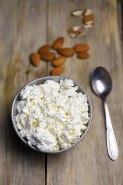 Bir kase süzme peynir ve badem. Sağlıklı gıda konsepti. Diyet öğle yemeği ya da kahvaltı. Keto diyeti..