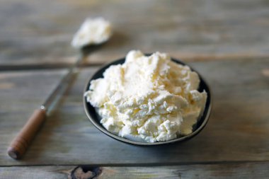 Tahta bir yüzeyde, kasede taze maskaralık peyniri..