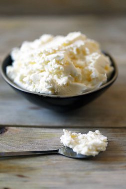 Tahta bir yüzeyde, kasede taze maskaralık peyniri..