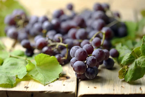 Blaue Trauben Und Traubenblätter Auf Einer Holzoberfläche Weinlese Weicher Fokus — Stockfoto