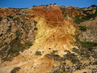 Açık mavi gökyüzü ile manzaralı kayalık bir yamaç. Arka planda güzel bir şekilde uzanıyor. Resmedilmeye değer bir manzara oluşturuyor.