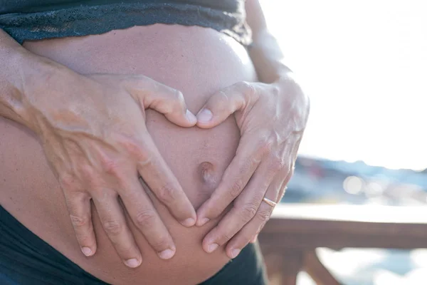 Mujer Embarazada Playa Las Manos Del Marido Forma Del Corazón — Foto de Stock