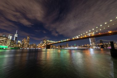 Manhattan siluetinin ve gece Brooklyn Köprüsü .
