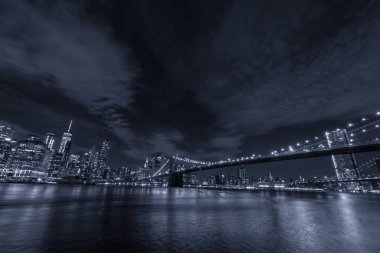 Manhattan ve Brooklyn köprüsünün silüeti, gece görüşü.