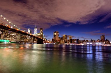 Manhattan siluetinin ve gece Brooklyn Köprüsü .