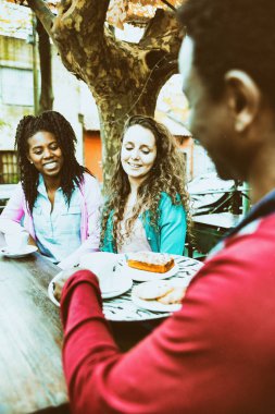 Siyah garson tarafından servis edilen iki genç kadın için kahve ve bisküvi.