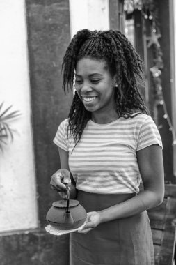 Genç siyah garson çay için sıcak su getiriyor.