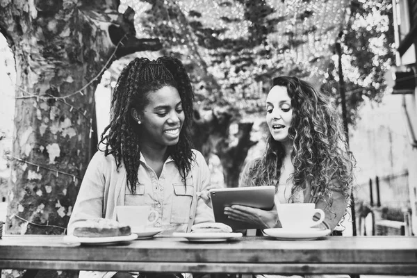 Két barátnő nézi a táblát a kávézóban. — Stock Fotó