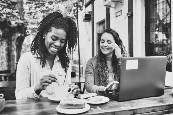 Due giovani donne, lavorano al computer portatile e bevono una tazza di caffè — Foto Stock