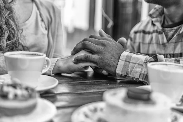 Deux mains amoureuses se rencontrent devant les bonbons et le café — Photo