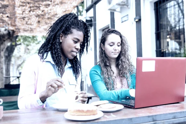 Συνάντηση εργασίας μεταξύ δύο νεαρών γυναικών μπροστά σε ένα καφέ, — Φωτογραφία Αρχείου