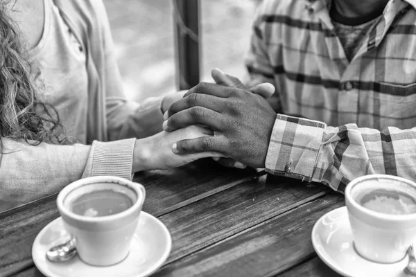Two hands in love meet in front of sweets and coffee