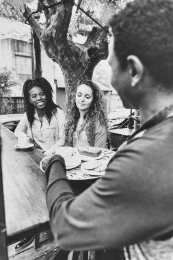 Siyah garson tarafından servis edilen iki genç kadın için kahve ve bisküvi.