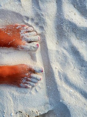 Maldiv sahilinde kırmızı diş minesinin renkli tırnaklarıyla ayaklar.