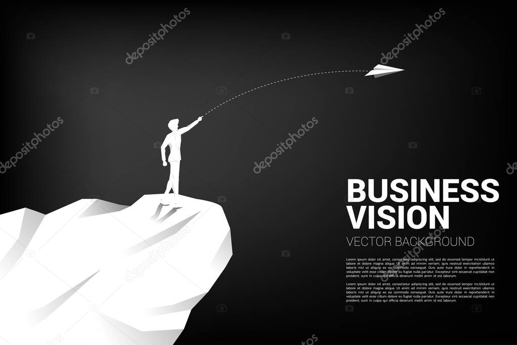 silhouette of businessman throw origami airplane from mountain cliff. Concept of business market vision mission start up