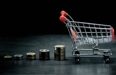 İçinde para yığınından büyüme grafiği olan alışveriş arabası. arkaplan c