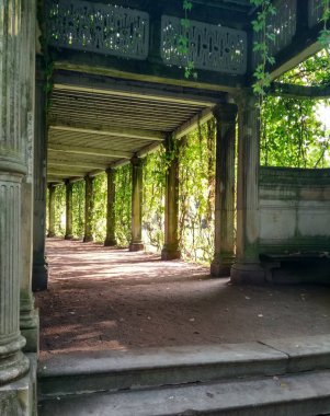 Parlak gün ışığında sağlayan yeşillikler ile büyümüş tarihi taş döken