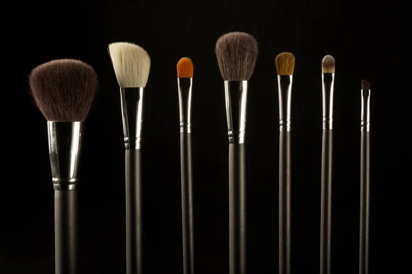 makeup brushes on a black background