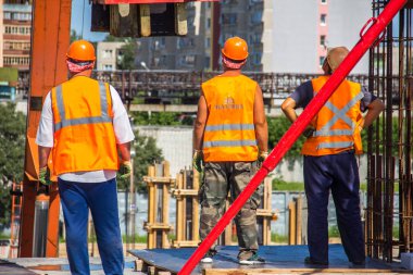 Rusya, Nizhniy Novgorod - 09 Temmuz 2015: işçiler bir bina yapım aşamasında vinç izleme ile kenarında bekliyoruz