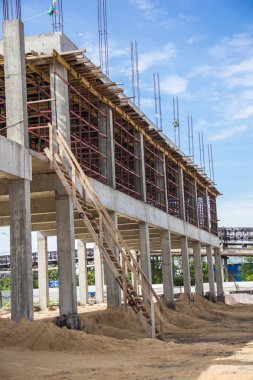 Üst kata sağlam beton, iskele ve ahşap merdivenden oluşan inşaat aşamasındaki binanın çerçevesi