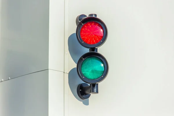 red and green traffic lights on the wall of an industrial building