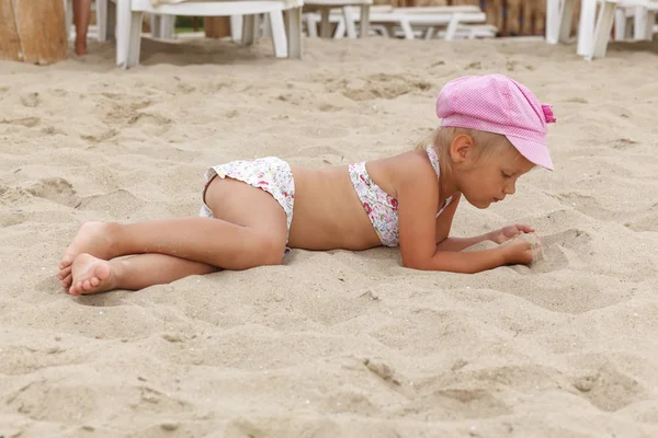 Uma Menina Boné Rosa Está Deitada Areia Procura Algo — Fotografia de Stock