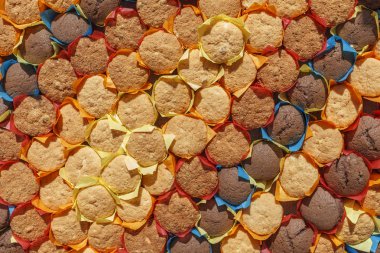 Cakes Background of fresh muffins in colored wrappers