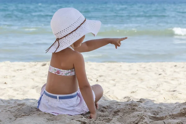 Holčička Bílém Plážovém Klobouku Bikinách Sedí Písku Moře Zády Kameře — Stock fotografie