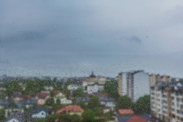 雨点落在窗户上 窗外是城市的朦胧景象 — 图库照片