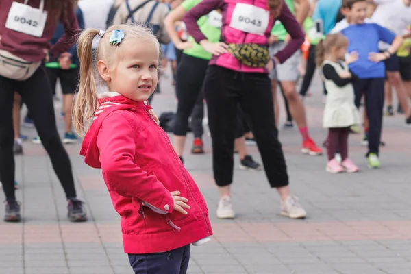 Little Girl Red Jacket Doing Exercise Background Crowd Athletes — Stock Photo, Image