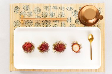 Vietnam kahve makinesi, altın kaşık ve çubuk ile zarif rambutan Asya çöl üstten görünüm.