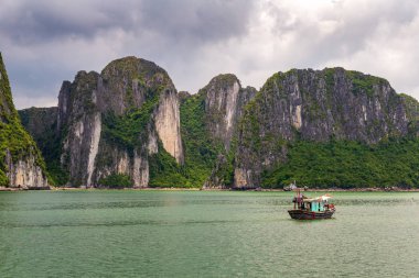 Halong bay kaya oluşumları ile Vietnam geleneksel yeşil balıkçı teknesi, Unesco Dünya doğal mirası, Vietnam.