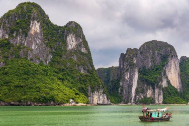 Halong bay kireçtaşı kayalıklarla Vietnamca geleneksel yeşil balıkçı teknesi, Unesco Dünya doğal mirası, Vietnam ile.